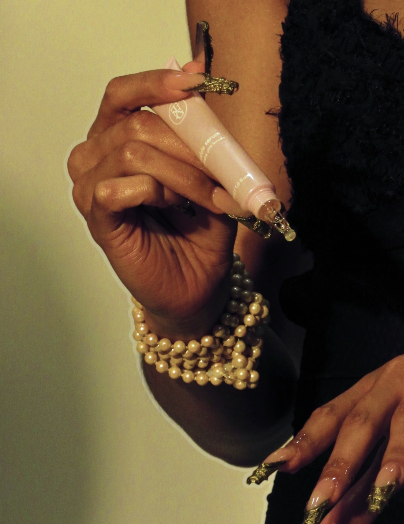 Model holding Glowé cuticle serum, editorial portrait